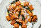 Plate of sweet potato gnocchi topped with grated cheese crispy sage and brown butter