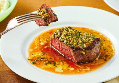 Steak DeBurgo dish on a plate with a piece held on a fork