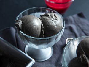 two scoops of black sesame ice cream in glass coupe