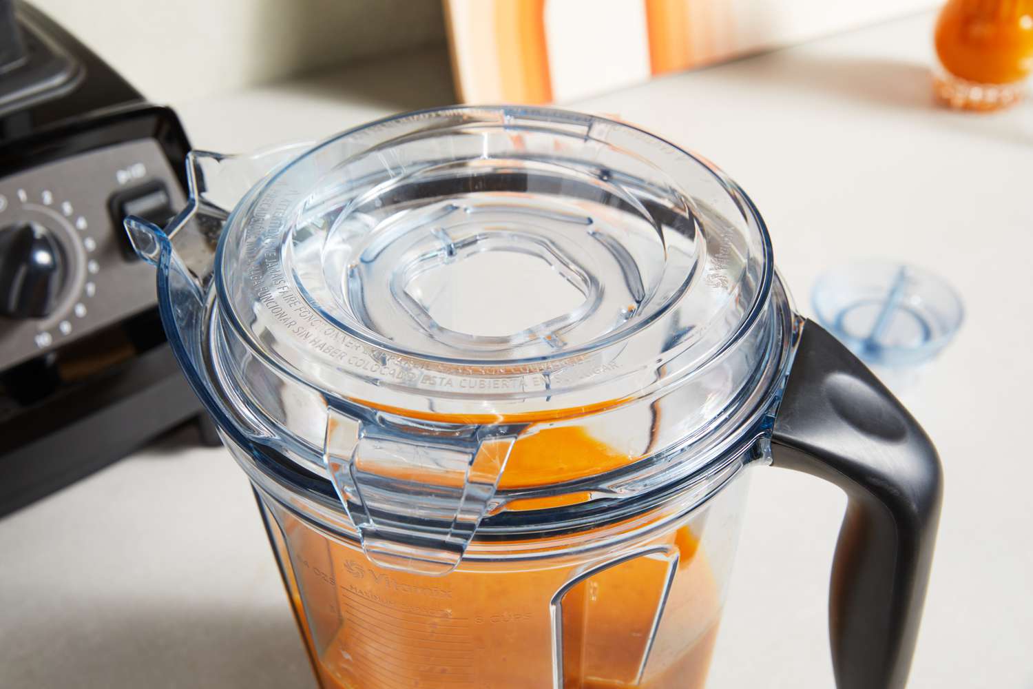 A closeup on the top of a Vitamix blender jar, featuring a wide pour spout.