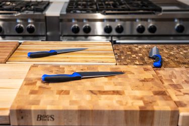 Chef's knives on the best wooden cutting boards in a kitchen