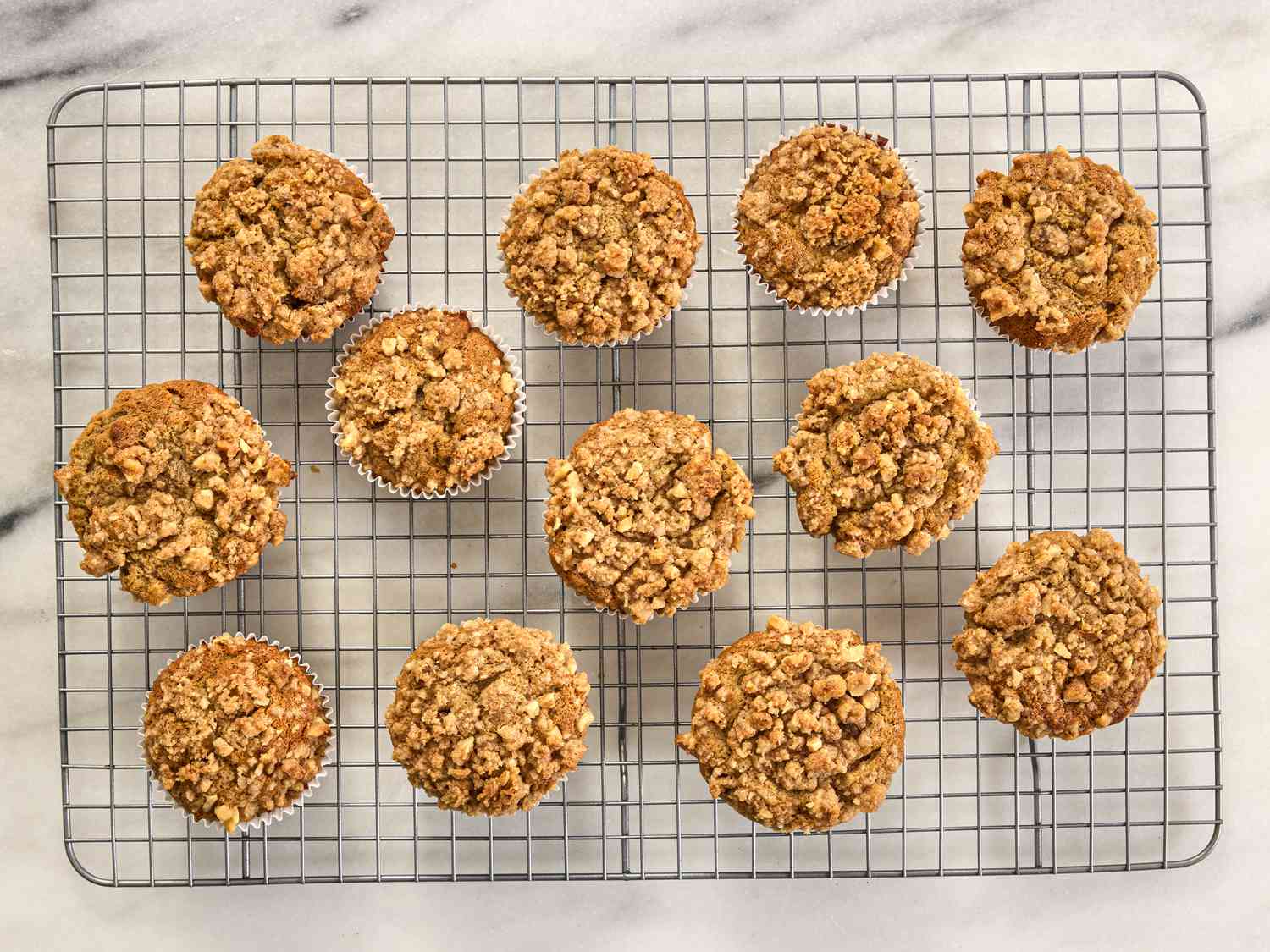 Banana nut muffins cooling on a rack on a white marble surface 