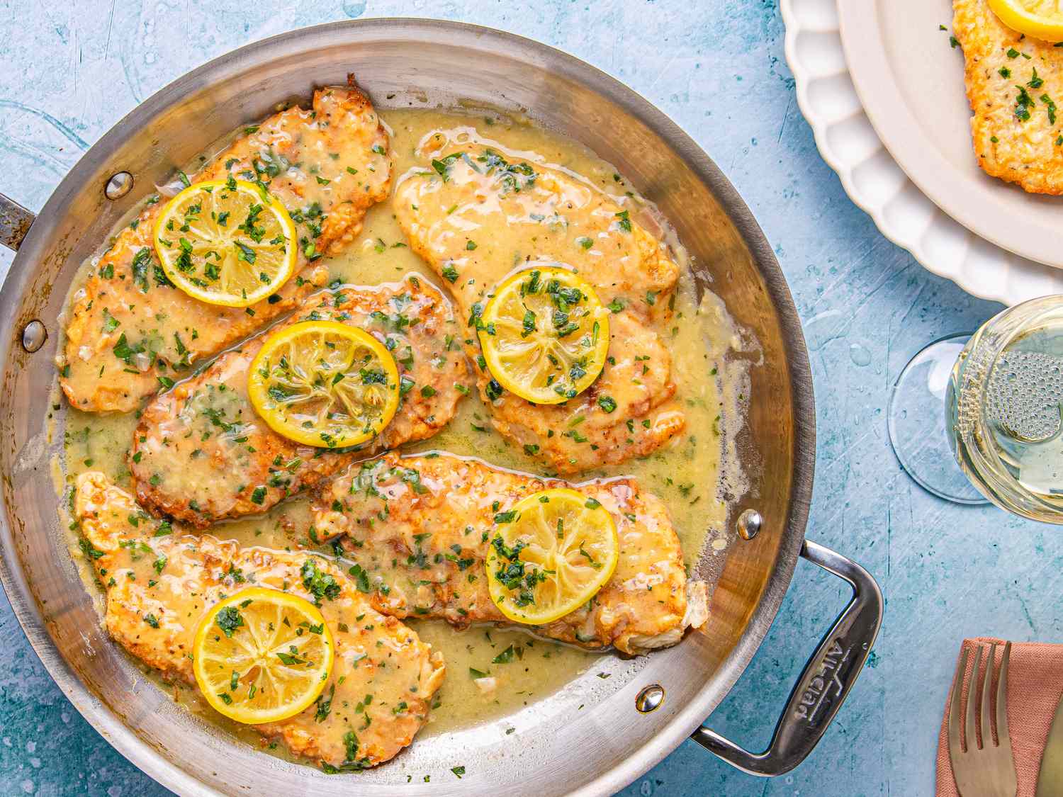 Chicken Francese served in a pan with lemon slices and sauce