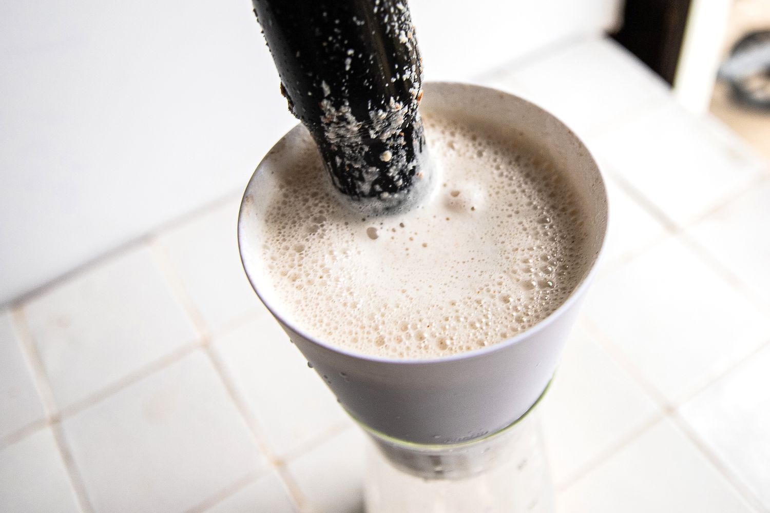 someone stirring nut milk in the chefn nut milk maker strainer
