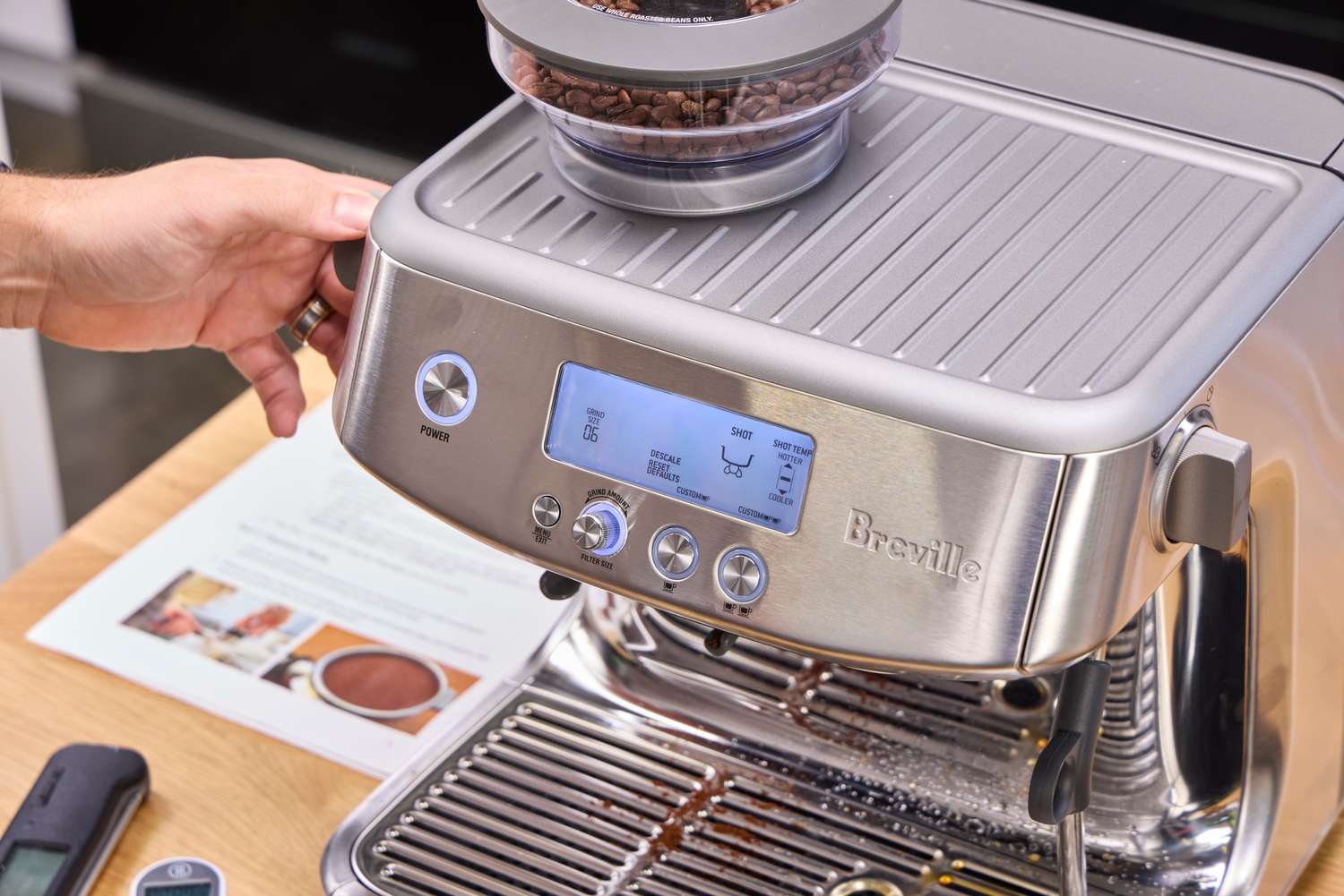 A person turns a dial on the Breville The Barista Pro Espresso Machine