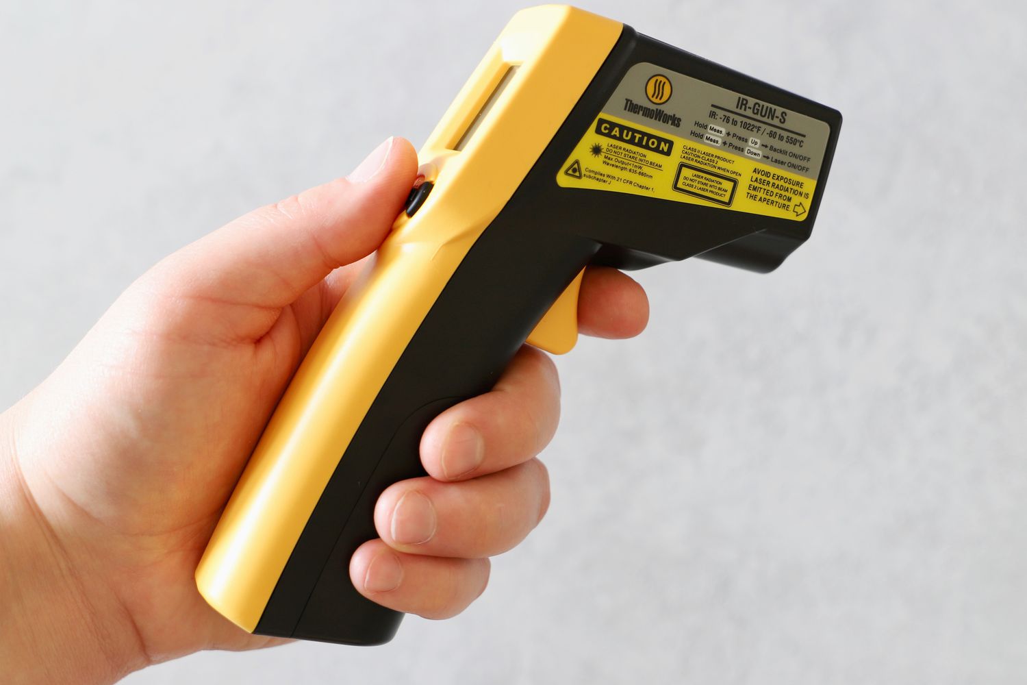A person holding a ThermoWorks infrared thermometer.
