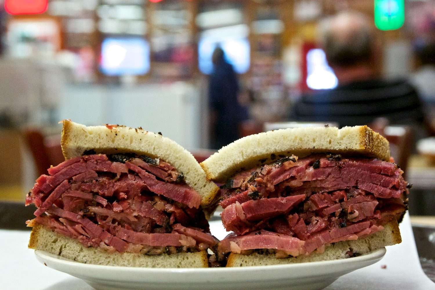 Pastrami on rye at Katz's deli, against blurred background.
