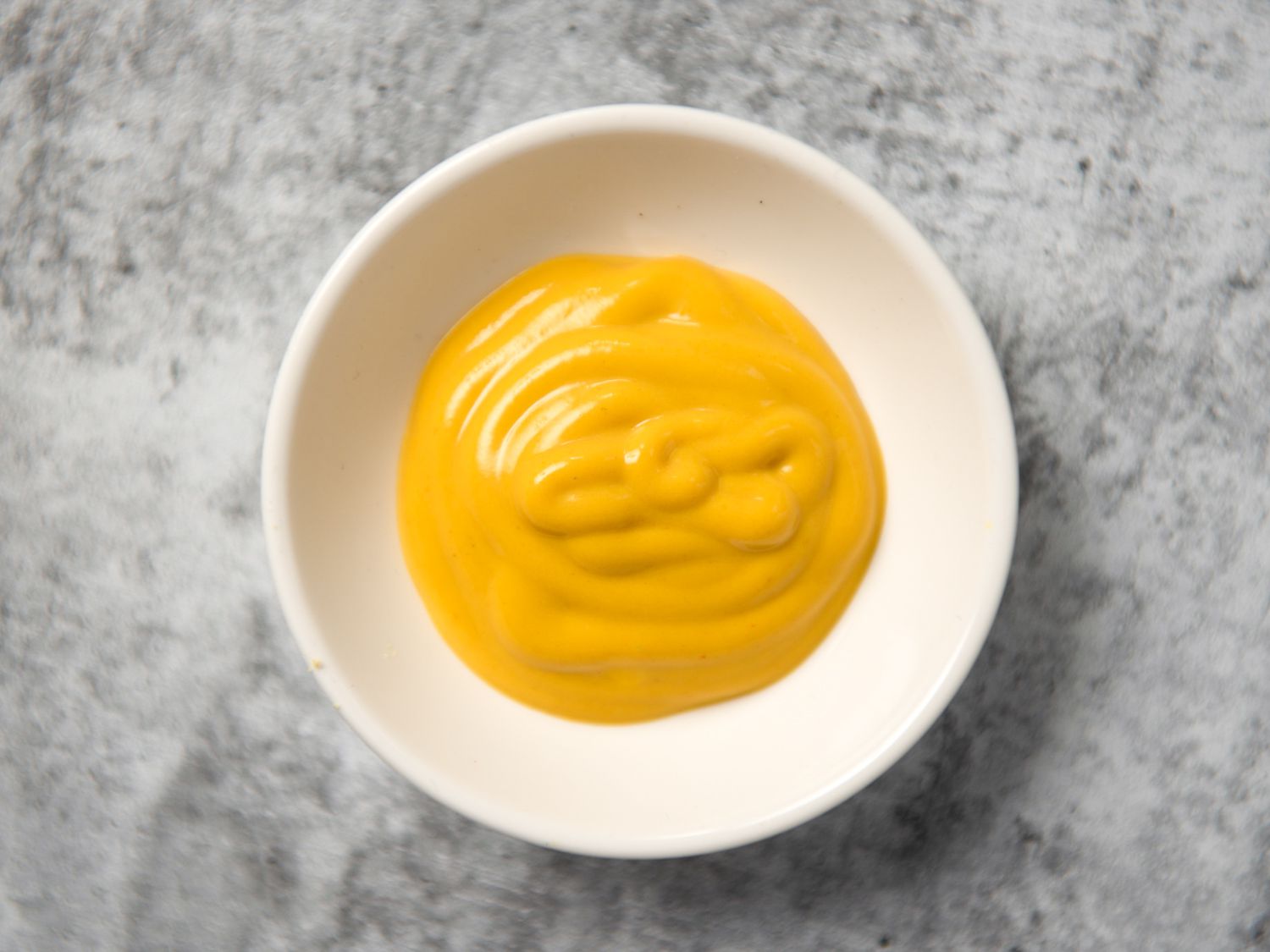 yellow mustard in a small white bowl
