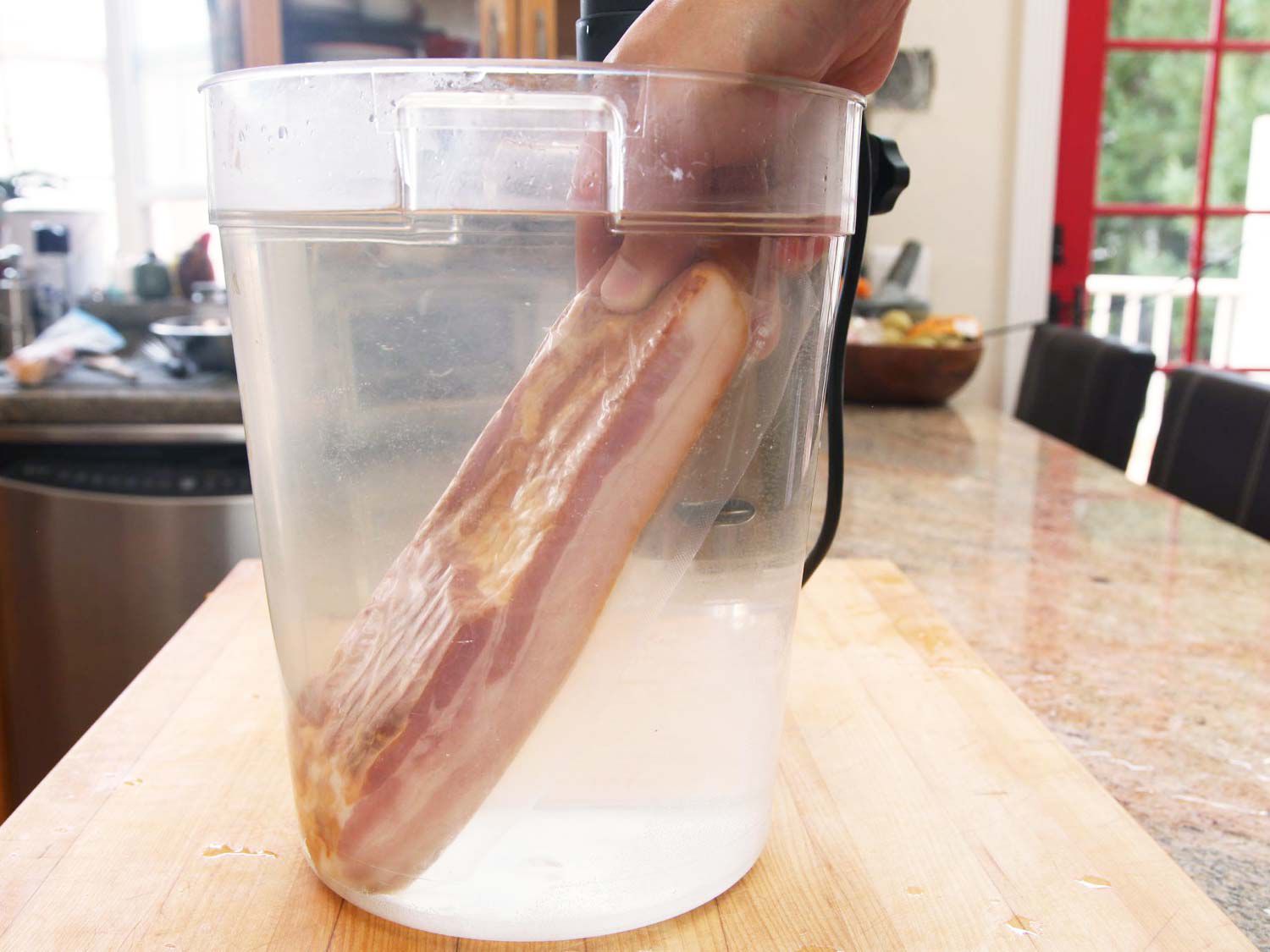 A package of bacon is placed in a water bath.
