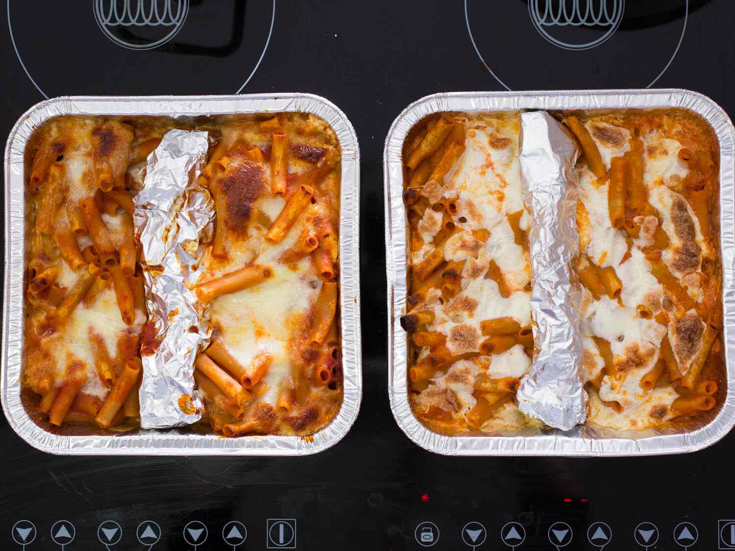 Side by side comparison of ziti baked with fresh mozzarella and low-moisture mozzarella in foil trays.