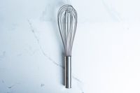 Winco Stainless Steel Piano Wire Whip on a marbled surface