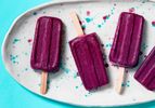 Blueberry yogurt popsicles arranged on a speckled platter