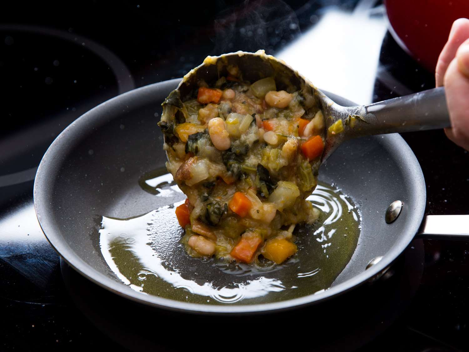 Ribollita that has been cooked to a thicker consistency is ladled into a small nonstick skillet and to fry in olive oil.