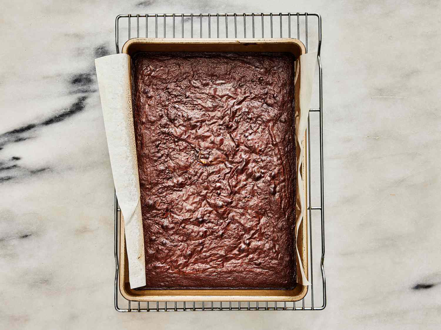 Baked brownie in baking pan with a shiny top 