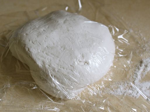 The finished tortilla dough ball, covered in plastic wrap.