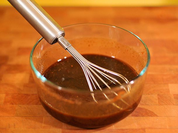 Hoisin sauce, honey, soy sauce, sherry, and five spice powder being whisked together in a bowl.
