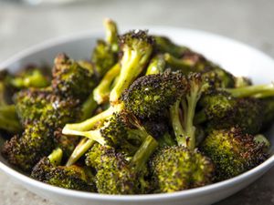 Close-up of roasted broccoli in a serving bowl.