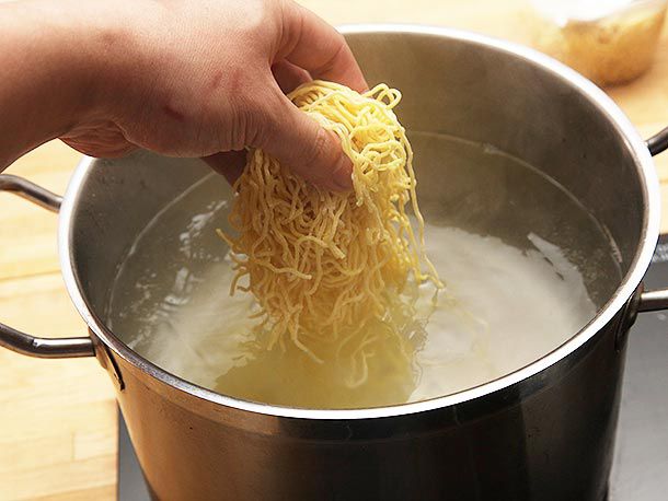 Dropping some fresh ramen noodles from Sun Noodle into a pot. 