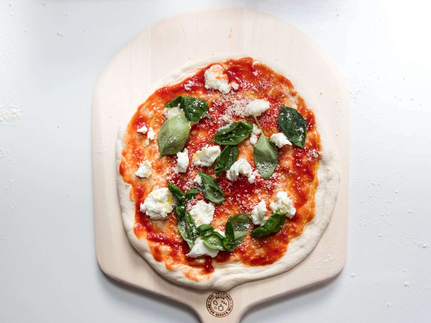 A margherita pizza ready to go in the oven.