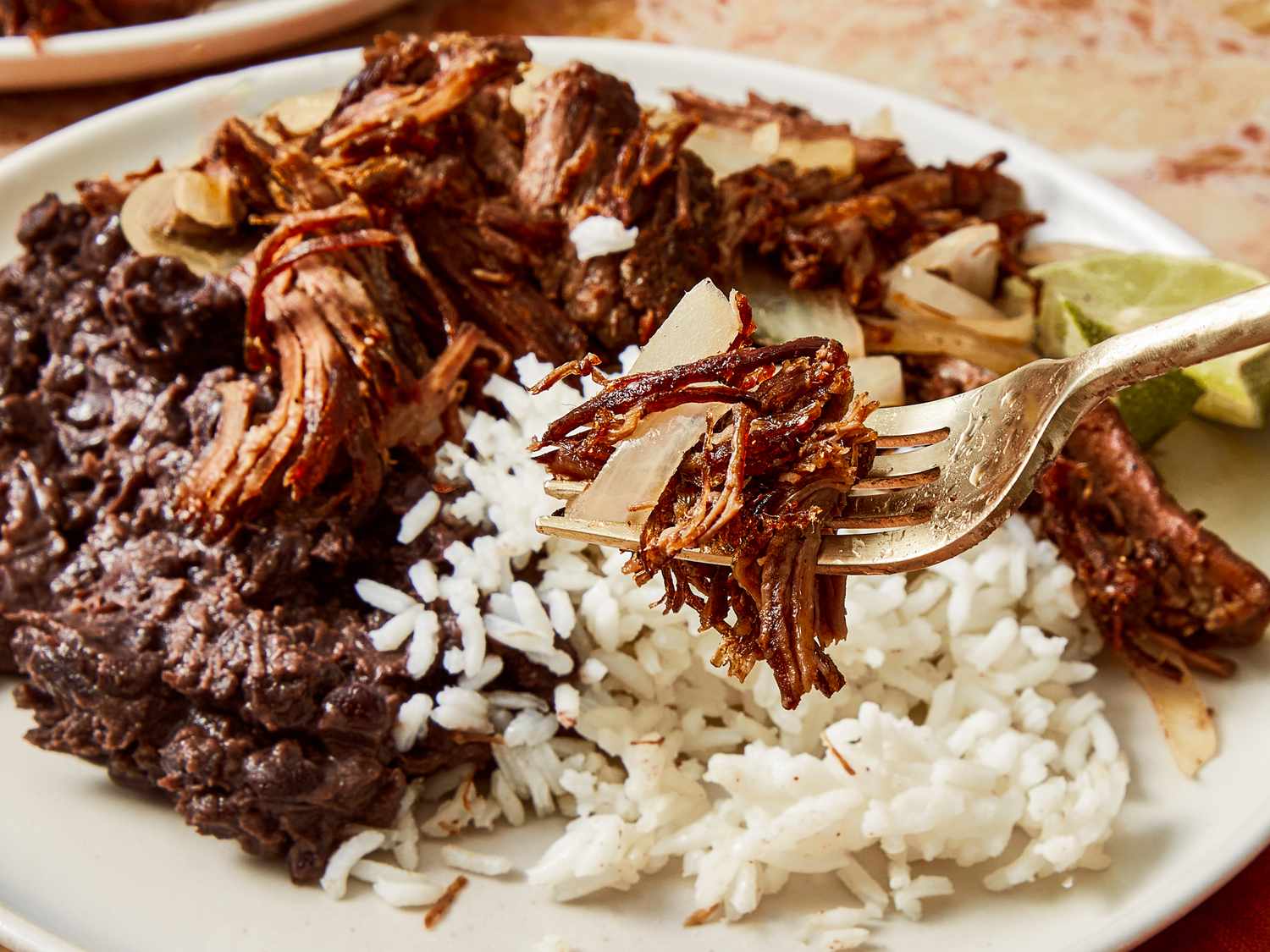 A plate of shredded beef with rice and black beans