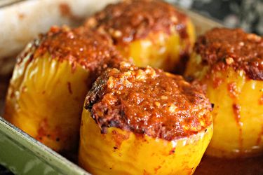 Closeup of a bkaing dish full of cheesy stuffed Mexican peppers.