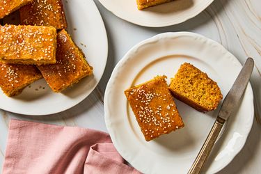 Gochujang scallion cornbread pieces served on plates topped with sesame seeds