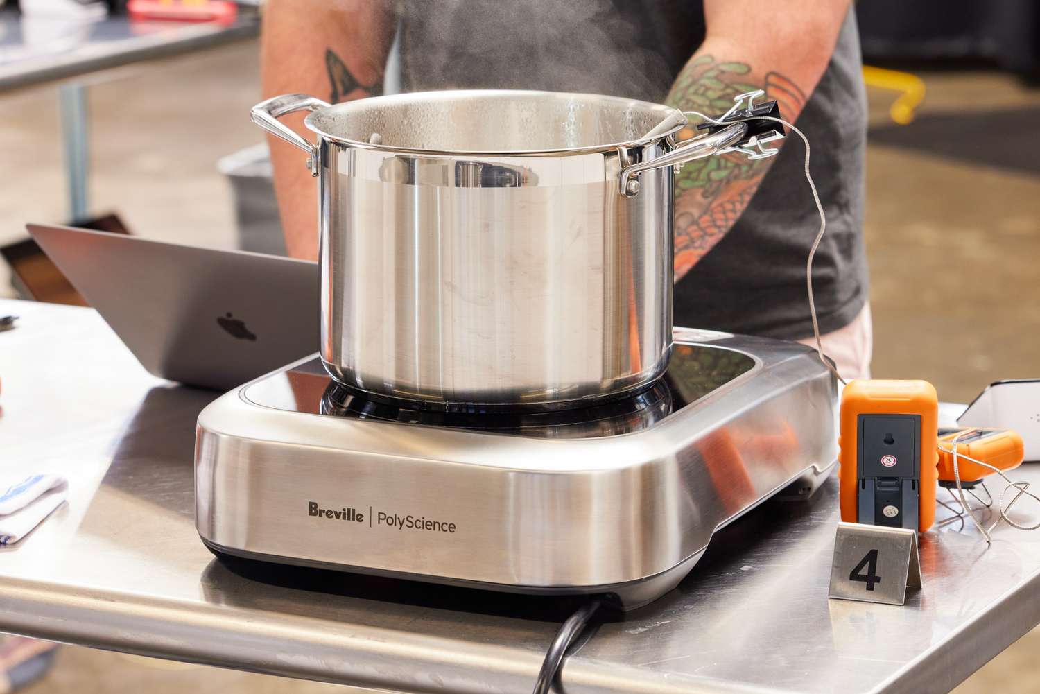 A pot steaming on a Breville PolyScience induction cooktop with a thermometer