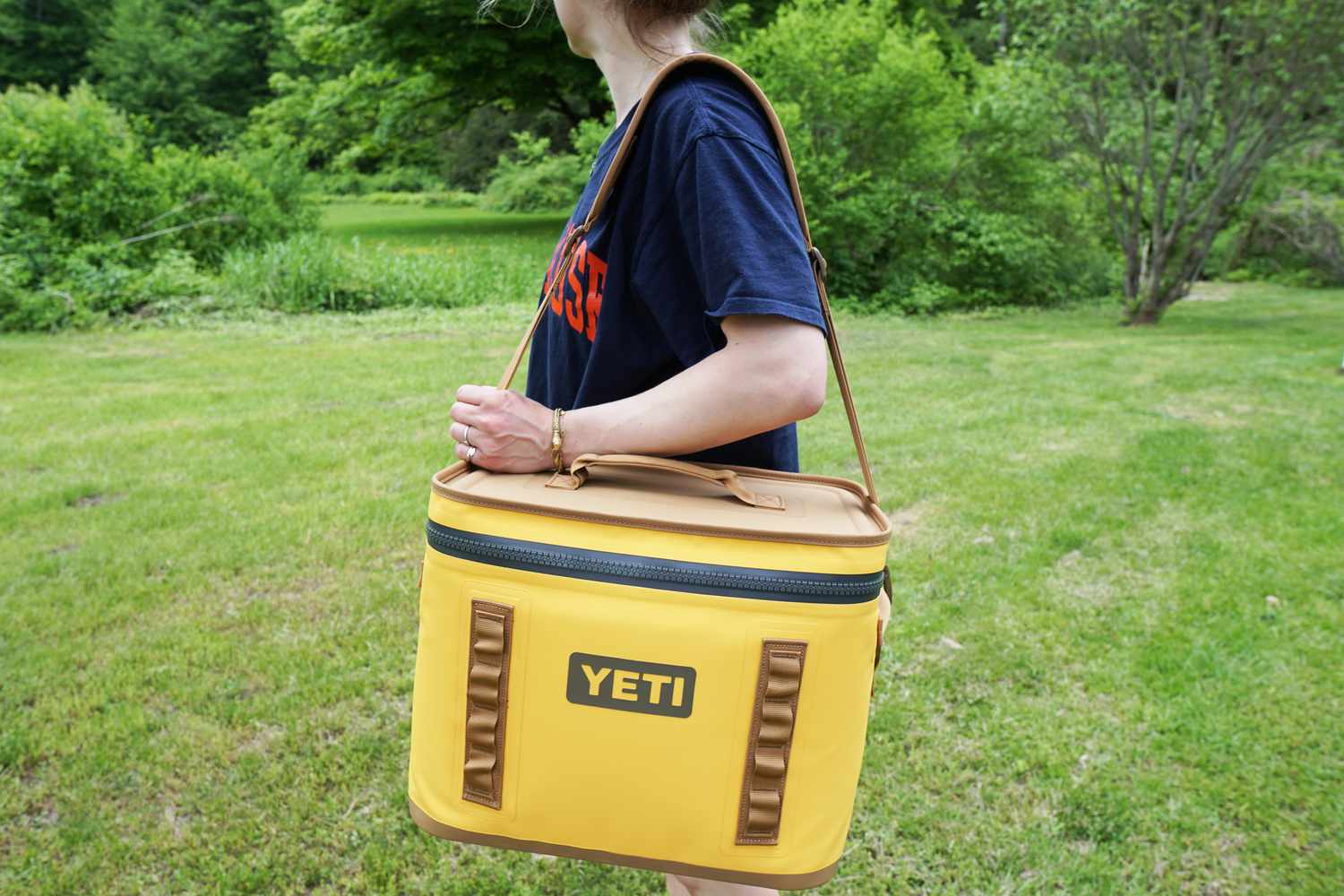 person holding yellow yeti soft cooler