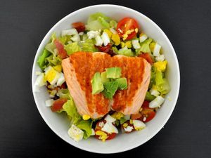 Overhead view of a California Cobb salad made with salmon and goat cheese.