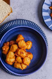 Akara on a deep blue bowl with a serving of white bread and a serving plate 