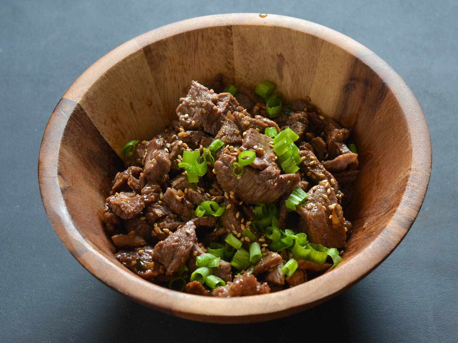 Close-up of wooden bowl containing cooked beef bulgogi.