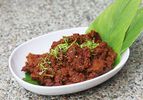 Beef rendang in an oval white bowl 