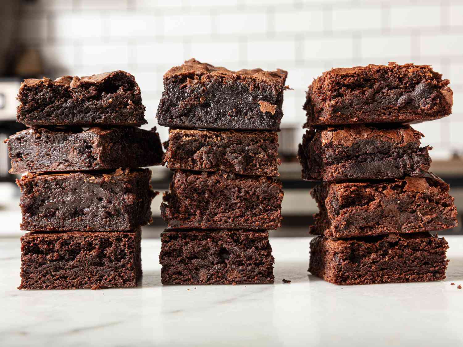 Brownies stacked on top of eachother, from the side, on kitchen counter 