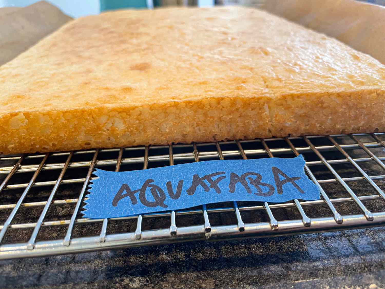 A baked good labeled as aquafaba placed on a cooling rack
