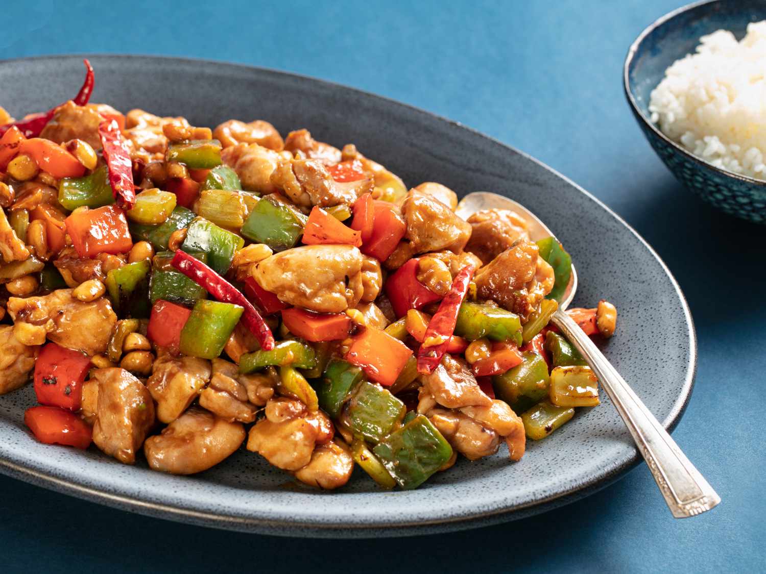 A plate of Kung Pao Chicken with spoon