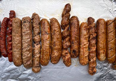 A line up of sausages grilled with different methods. 