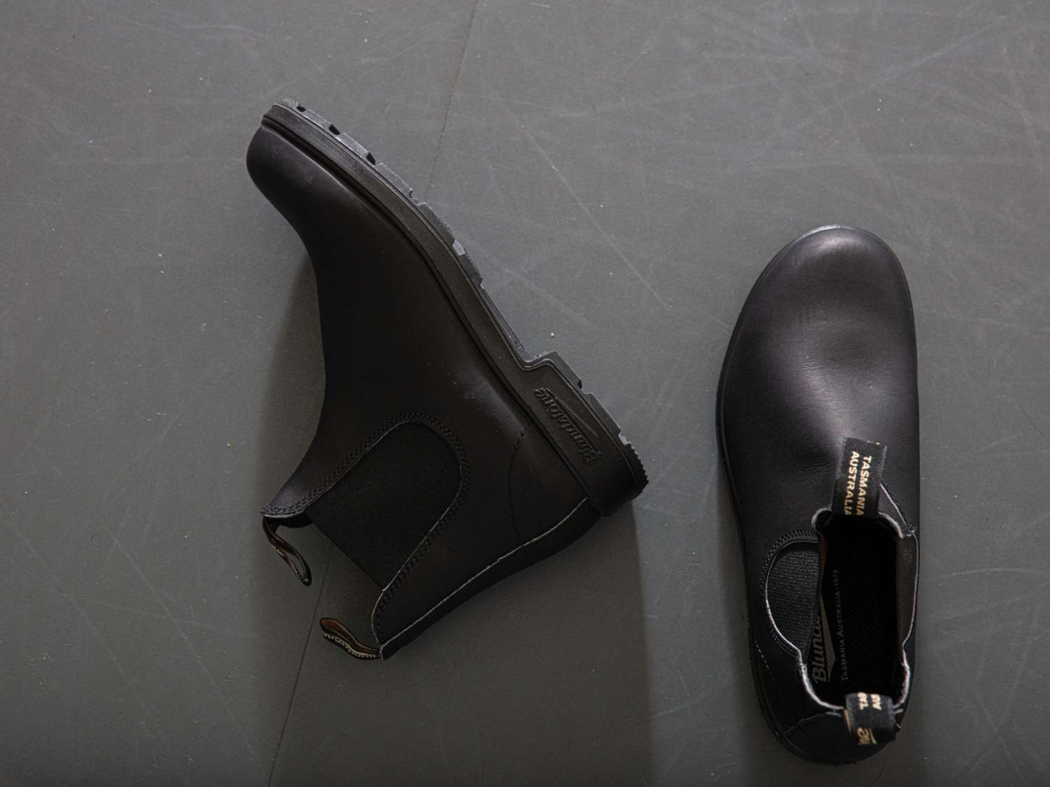 A pair of Blundstone boots on a grey floor.