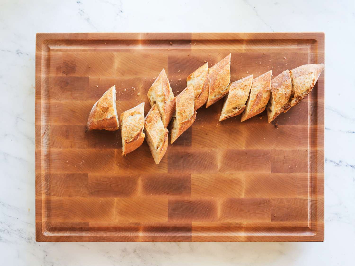 A sliced baguette on a wooden carving board