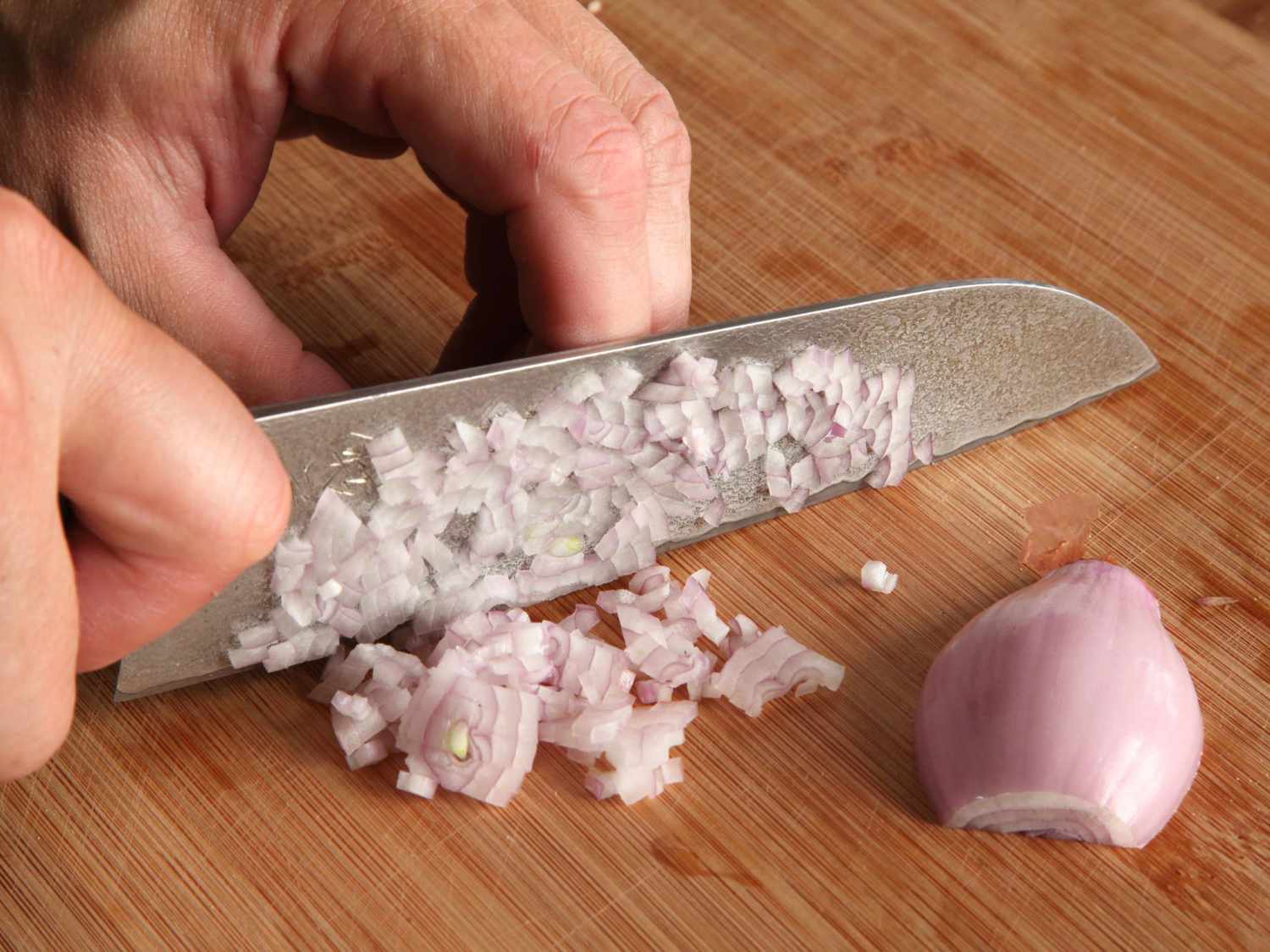 Author minces a shallot with a santoku knife.