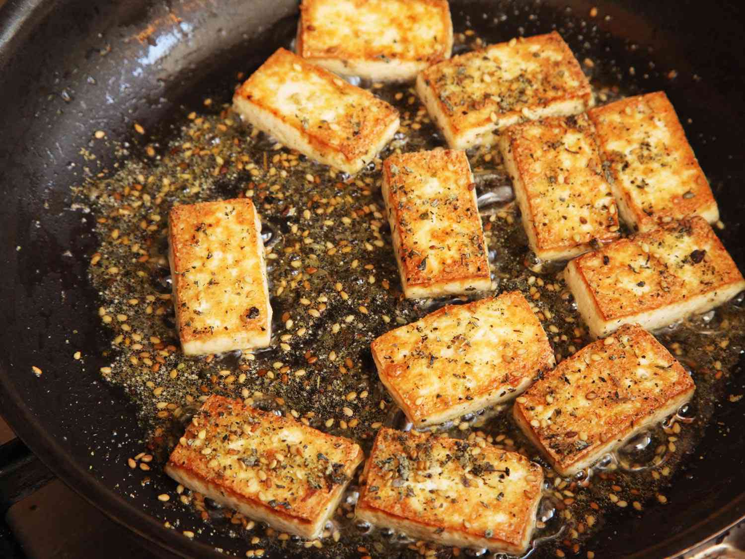 Tofu and zaatar frying in a pan.