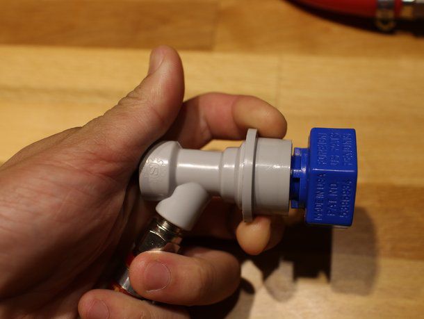 A hand holding the carbonator cap.