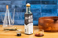 Bottle of black sesame oil on a kitchen counter with cooking items