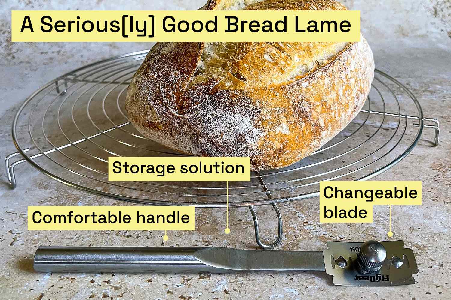 A bread lame on a kitchen counter next to a freshly baked loaf of bread