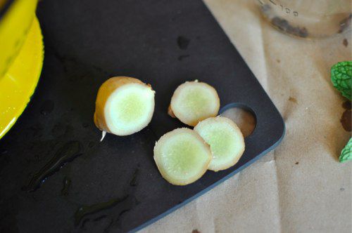 Closeup of sliced ginger root on black cutting board