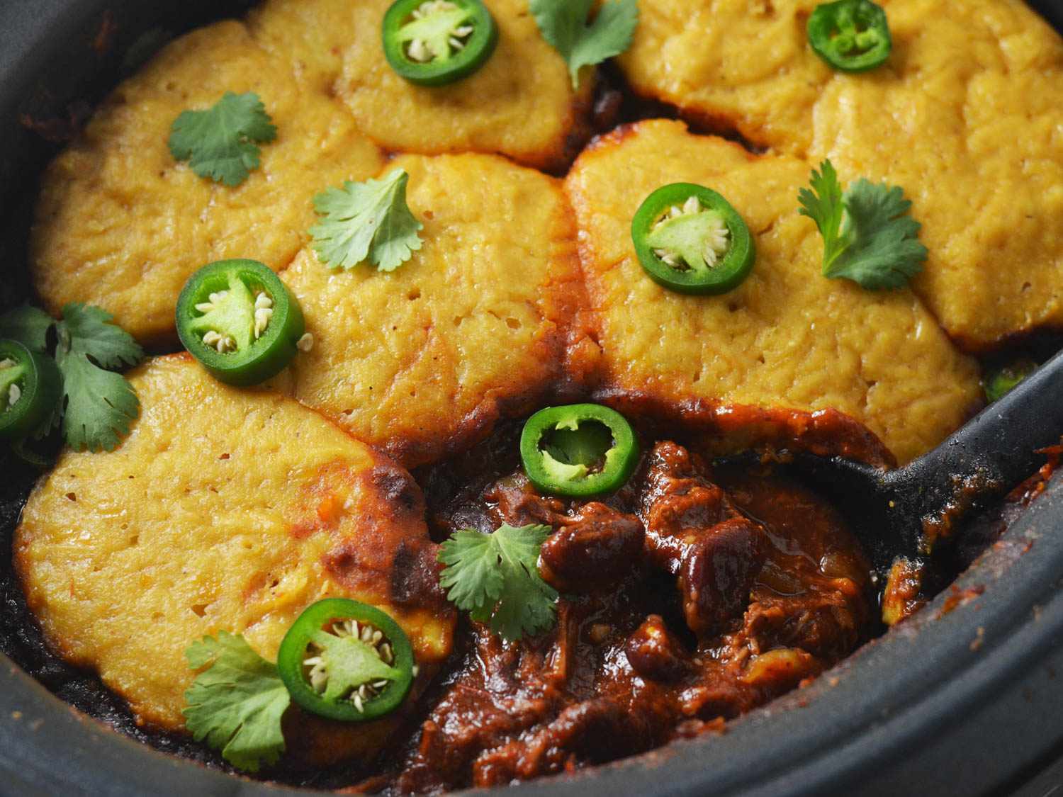 close up of the finished chili with cooked cornbread on top