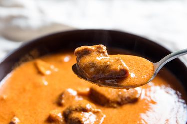 A spoonful lifted from a bowl of rich Ghanaian goat and tripe soup. 