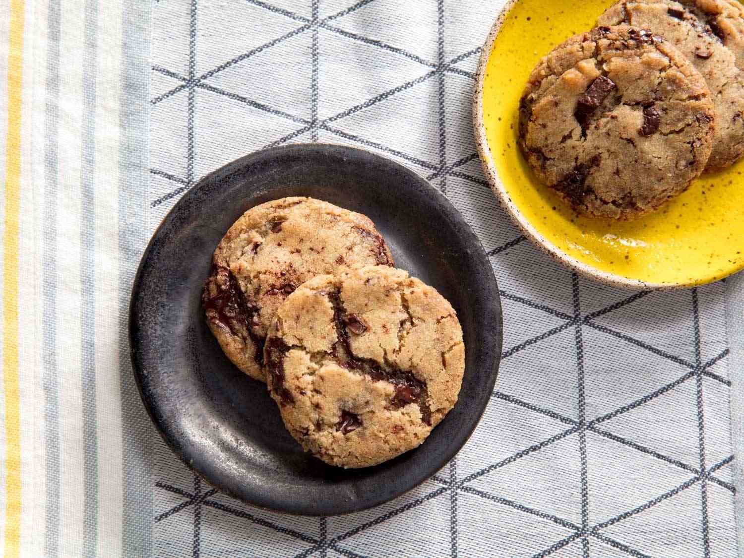 Vegan chocolate chip cookies on black and yellow plates 
