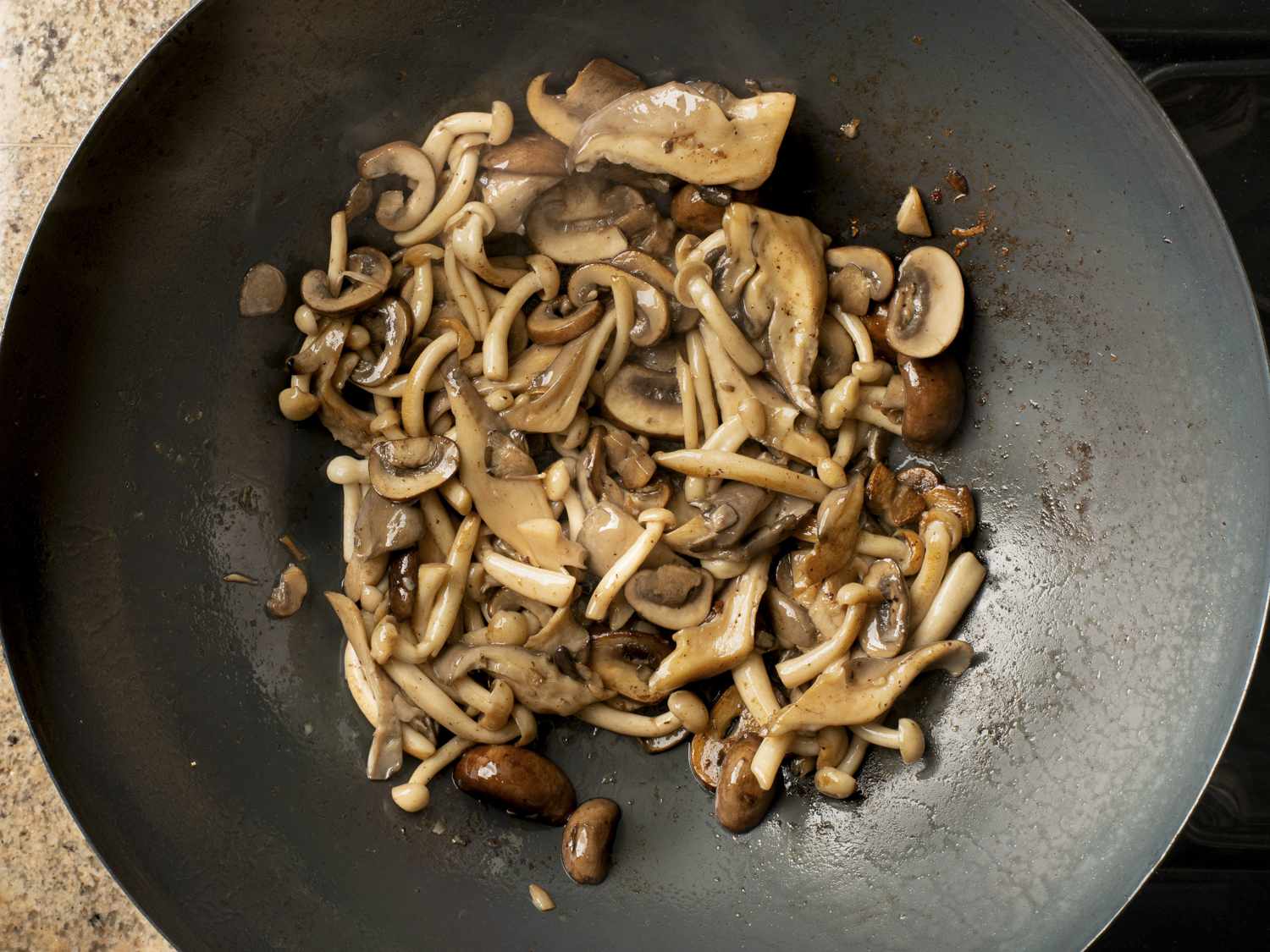 Mushrooms cooking in wok after the mushroom juice has evaporated.