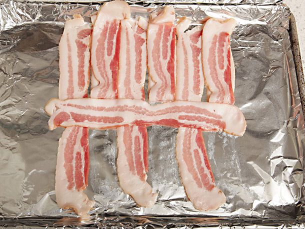 Every other bacon strip is folded up and a strip is placed horizontally across the center of the slices.