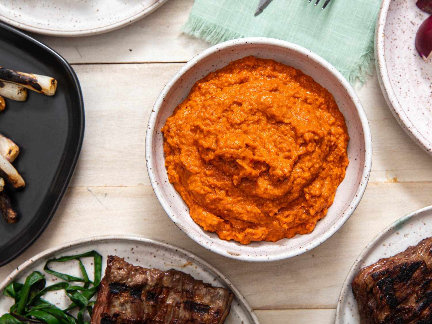 Overhead view of a white bowl brimming with romesco sauce.